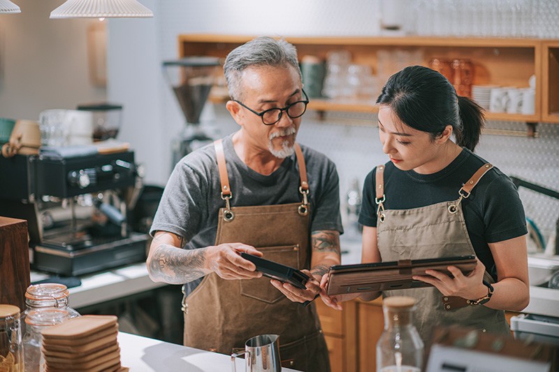 Baristas showing eachother information on mobile device